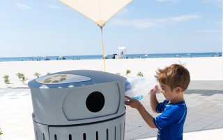 boy throws away trash at the Beach
