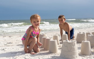 children building sandcastles on the beach