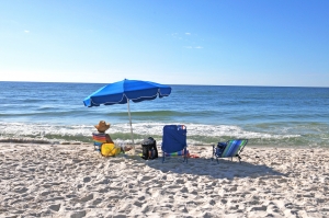 person sitting under umbrella at the beach